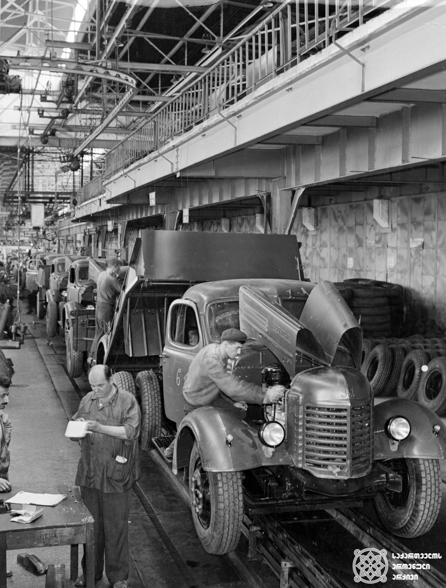 ქუთაისის ორჯონიკიძის სახელობის საავტომობილო ქარხნის მთავარი კონვეიერი.  1957 წელი. <br>
Chief Conveyor of Kutaisi Orjonikidze Automobile Plant. 1957.