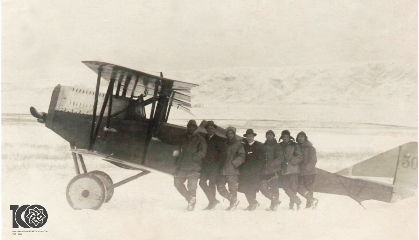 ქართველი და იტალიელი მფრინავები იტალიურ „ანსალდოს“ ფირმის SVA-10 აეროპლანის ფონზე. 
1920 წელი.
<br>
 Georgian and Italian pilots on the background of the Italian “Ansaldo” company SVA-10 airplane. 1920