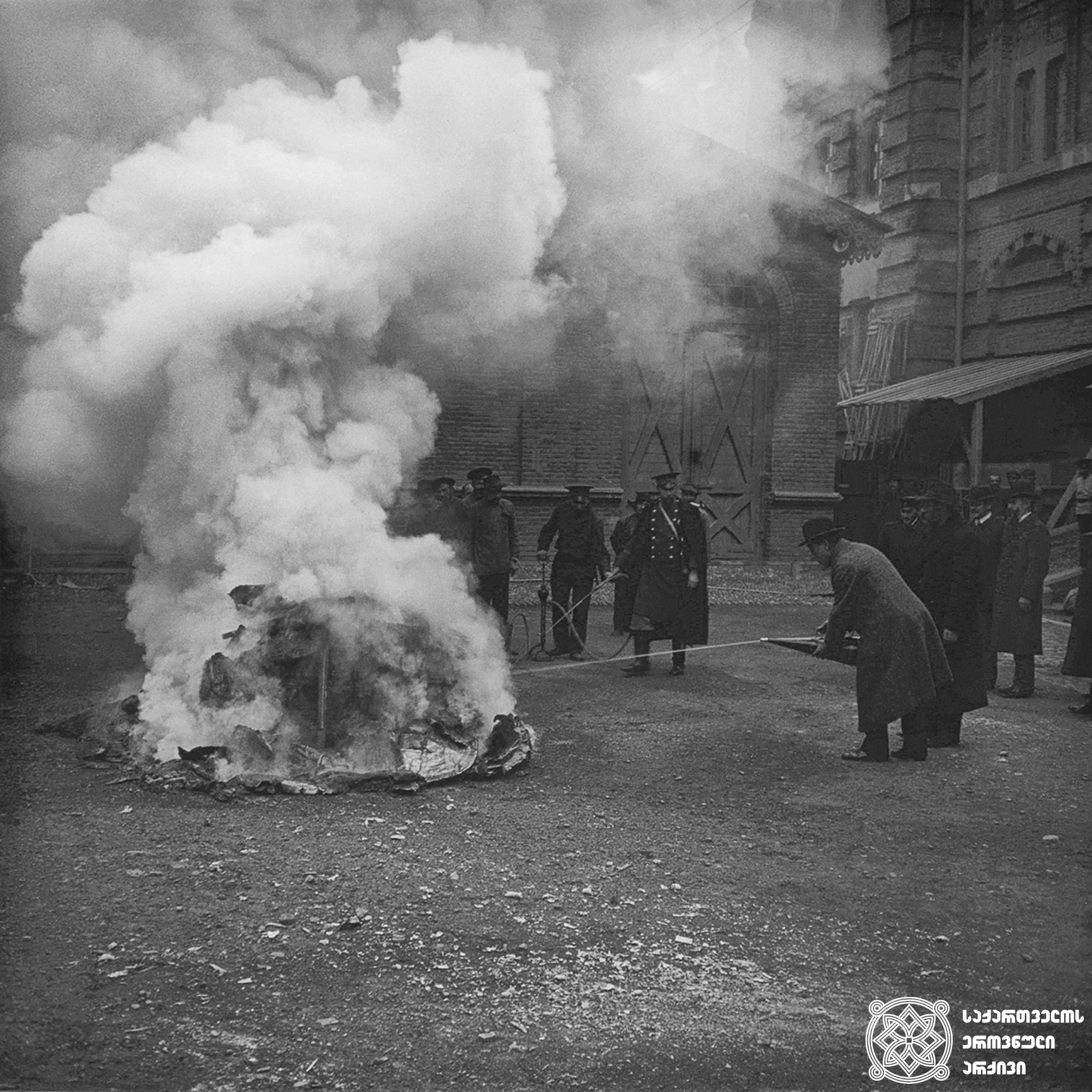 მეხანძრეების სწავლება, ხელოვნური ხანძრის ქრობა თბილისის სახაზინო თეატრის ეზოში <br>
1913 წელი <br>
გიგლო ყარალაშვილის კოლექცია <br>

Training of firefighters, extinguishing artificial fires in the yard of Tbilisi Treasury Theater <br>
1913 <br>
Giglo Karalashvili collection <br>