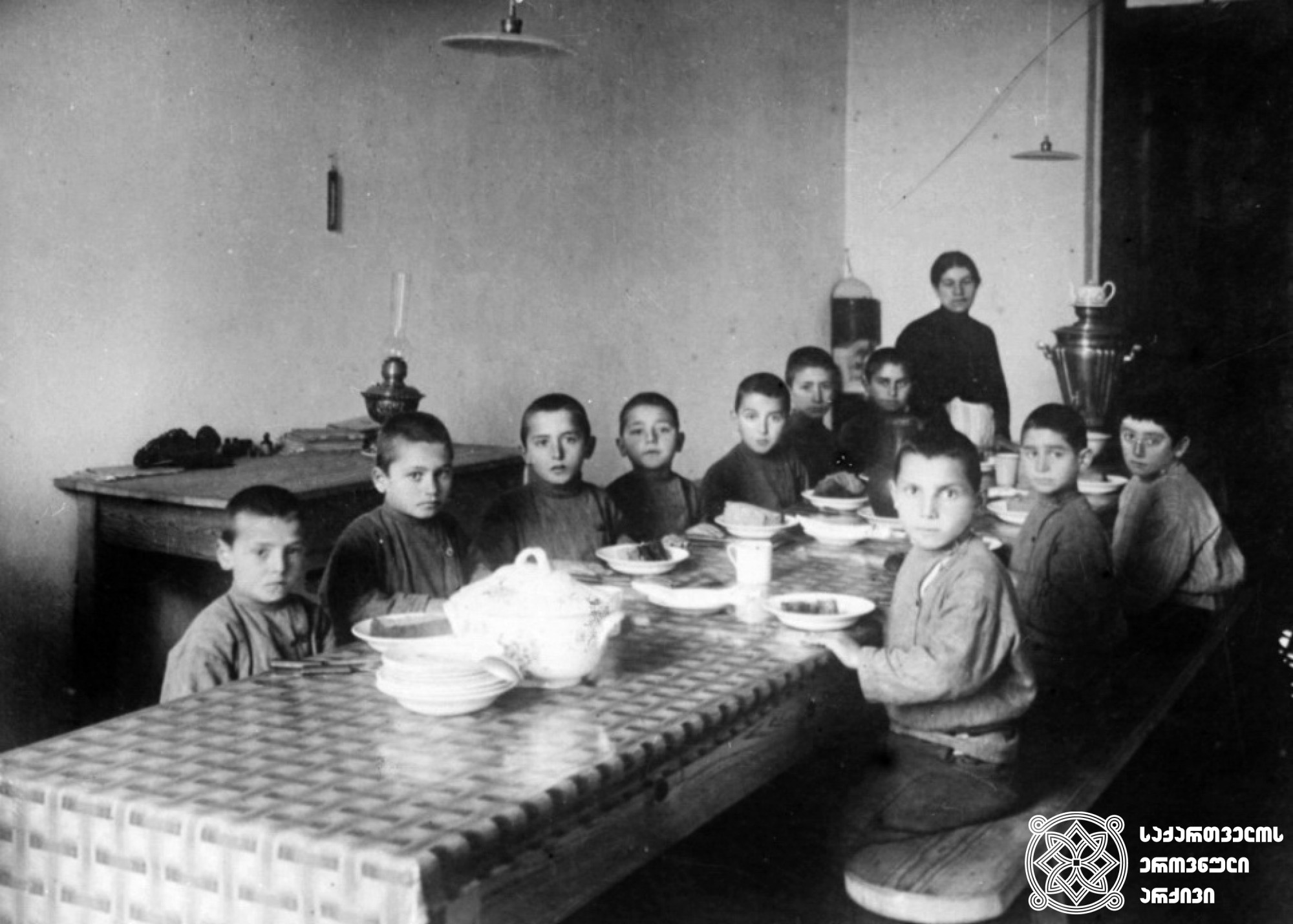 სოხუმის  სასწავლებელთან  არსებული  თავშესაფრის ბავშვები  სადილობის  დროს <br>
1916  წელი <br>
Children of the Sokhumi school near the shelter during lunch <br>
1916