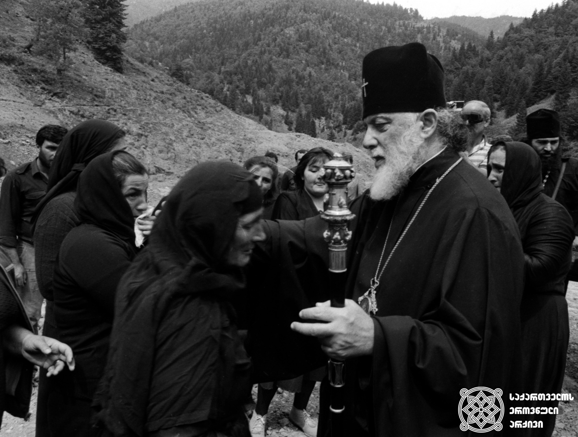 ილია II სრულიად საქართველოს კათოლიკოს-პატრიარქის შეხვედრა სტიქიით დაზარალებულებთან <br>
წაბლანა, 1989 წელი <br>
Meeting of Ilia II, Catholicos-Patriarch of All Georgia, with natural disaster victims <br>
Tsablana, 1989