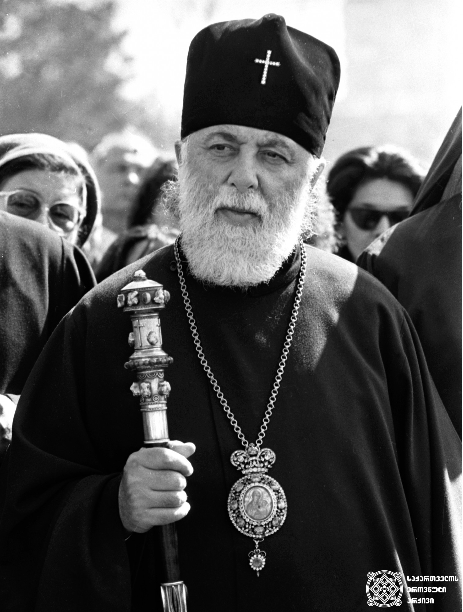 კინოსტიდიისა და „ქართული ფილმის“ ტერიტორიაზე ეკლესიის ასაშენებელი ადგილის კურთხევის დროს <br>
თბილისი, 1990-იანი წლები <br>
During the blessing of the site for the construction of a church on the grounds of the "Georgian Film" and the film studio <br>
Tbilisi, 1990s <br>