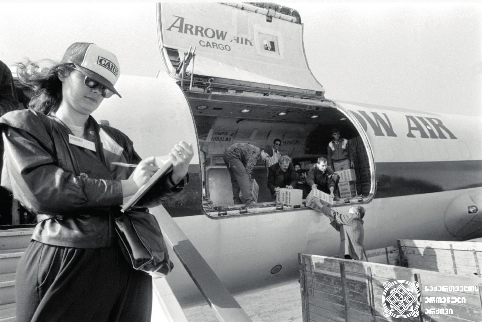 აშშ-ის მიერ საქართველოსთვის გაგზავნილი ჰუმანიტარული ტვირთი თბილისის აეროპორტში. <br>
1993 წელი.<br>
ვლადიმერ ვალიშვილის ფოტო.<br>
Humanitarian cargo, sent by United States to Georgia, at Tbilisi airport.<br> 
1993. <br>
Photo by Vladimer Valishvili.