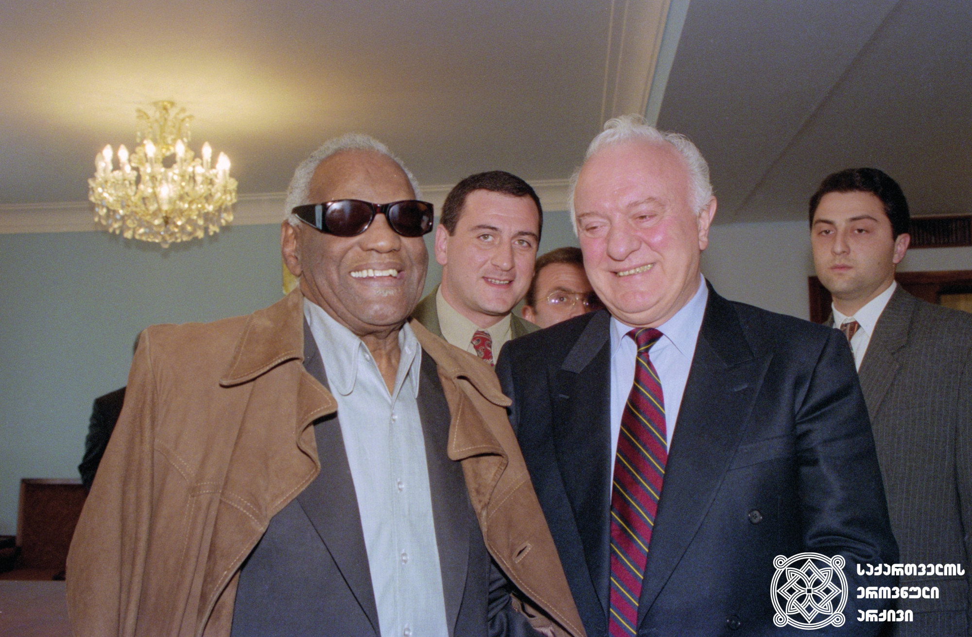 ამერიკელი მუსიკოსი რეი ჩარლზი მიღებაზე საქართველოს პრეზიდენტ ედუარდ შევარდნაძესთან. <br>
თბილისი. 1996 წელი. <br>
სერგო ედიშერაშვილის ფოტო. <br>
American musician Ray Charles at a reception with the President Eduard Shevardnadze. <br> Tbilisi. 1996. <br>
Photo by Sergo Edisherashvili.