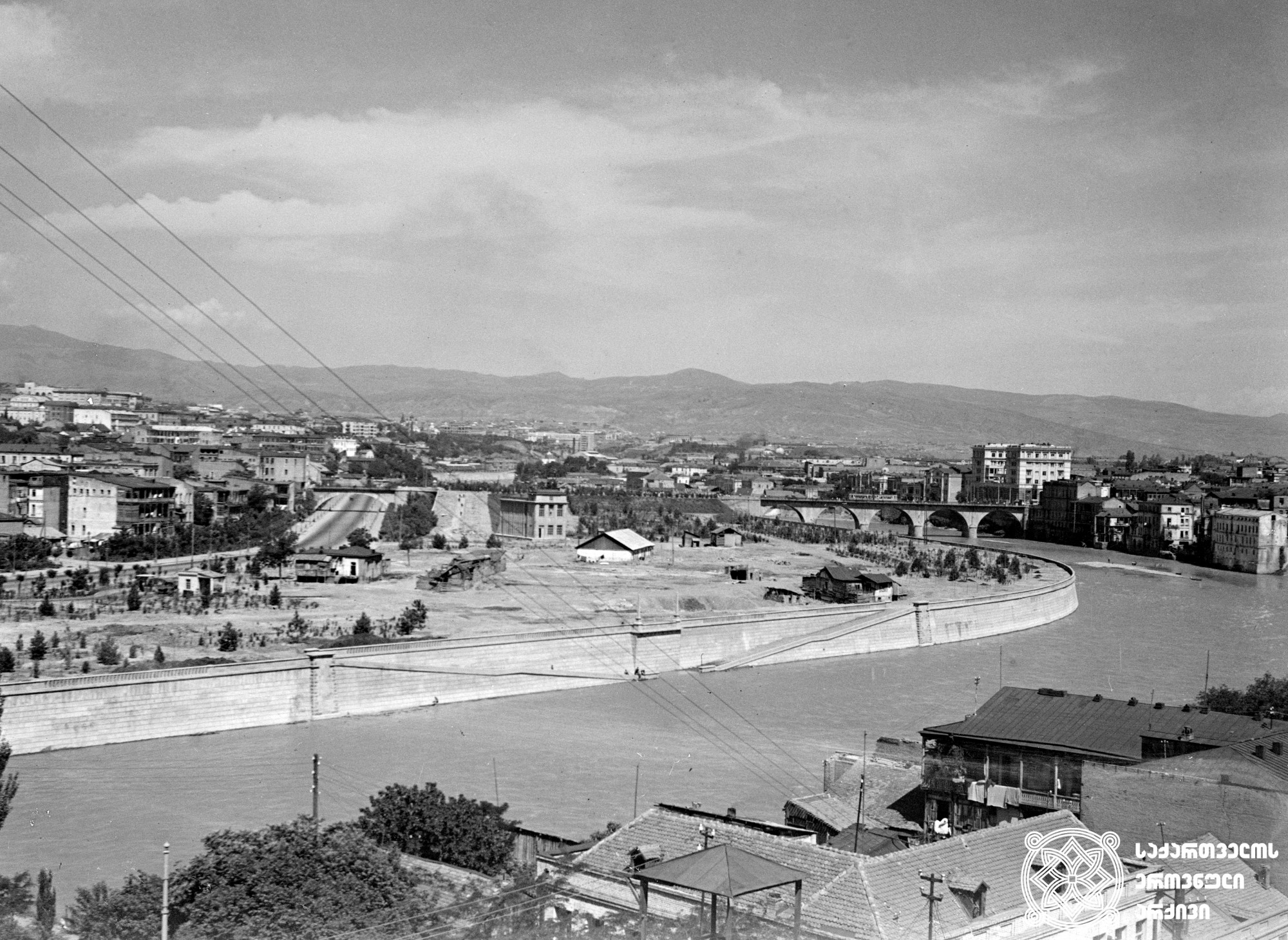 თბილისის მარჯვენა სანაპიროს ხედი და კარლ მარქსის სახელობის ხიდი (დღევანდელი ჩუღურეთის ხიდი. დედაენის ბაღის მიმდებარედ). <br>თბილისი. ფოტო: ვ. ჩერკასოვი. <br>1939. <br>
View of Tbilisi right embankment and Karl Marx bridge (today Chughureti Bridge, Deda Ena Park area). Tbilisi. <br>Photo by V. Cherkasov. <br>1939.