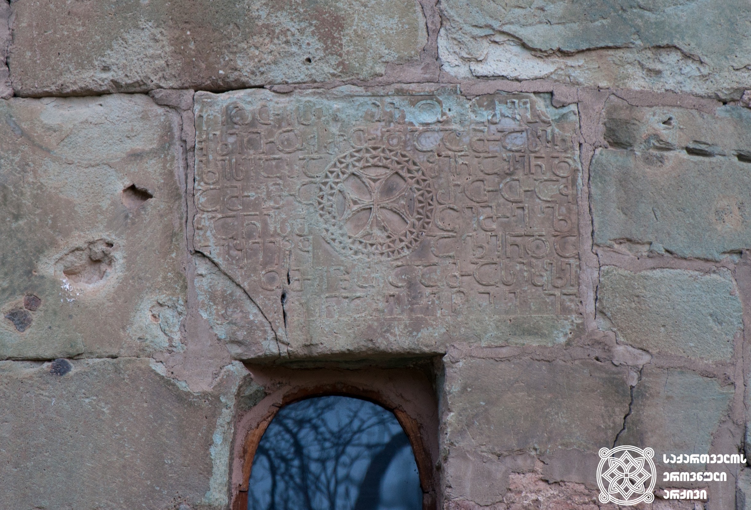 ბოლნური ჯვარი და დავით ეპისკოპოსის ასომთავრული წარწერა, ქართული დამწერლობის ერთ-ერთი უძველესი ნიმუში. ბოლნისის სიონის ტაძარი, აღმოსავლეთის კედელი, V საუკუნე<br>
The Bolnisi Cross and the asomtavruli inscription of Bishop David. The inscription represents one of the oldest samples of the Georgian scripts. Bolnisi Sioni Church, the eastern wall, 5th century