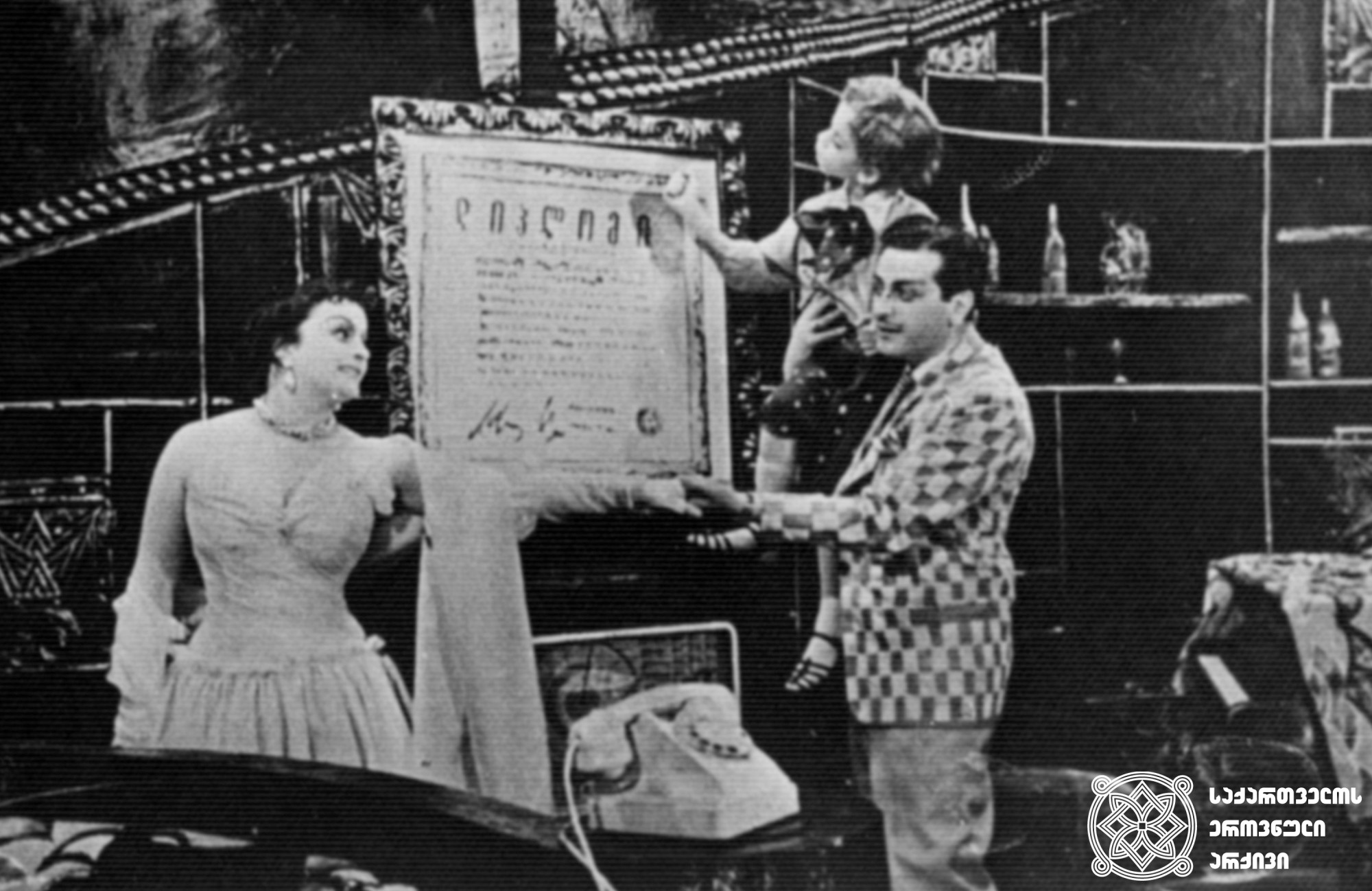 სცენა სპექტაკლიდან „ფილოსოფიის დოქტორი“, მილორდი - რამაზ ჩხიკვაძე. კლარა - მედეა ჩახავა. <br>
1956 წელი. <br>

Scene from the play "Doctor of Philosophy", Ramaz Chkhikvadze as Milord, Medea Chakhava as Klara. <br>
1956. <br>