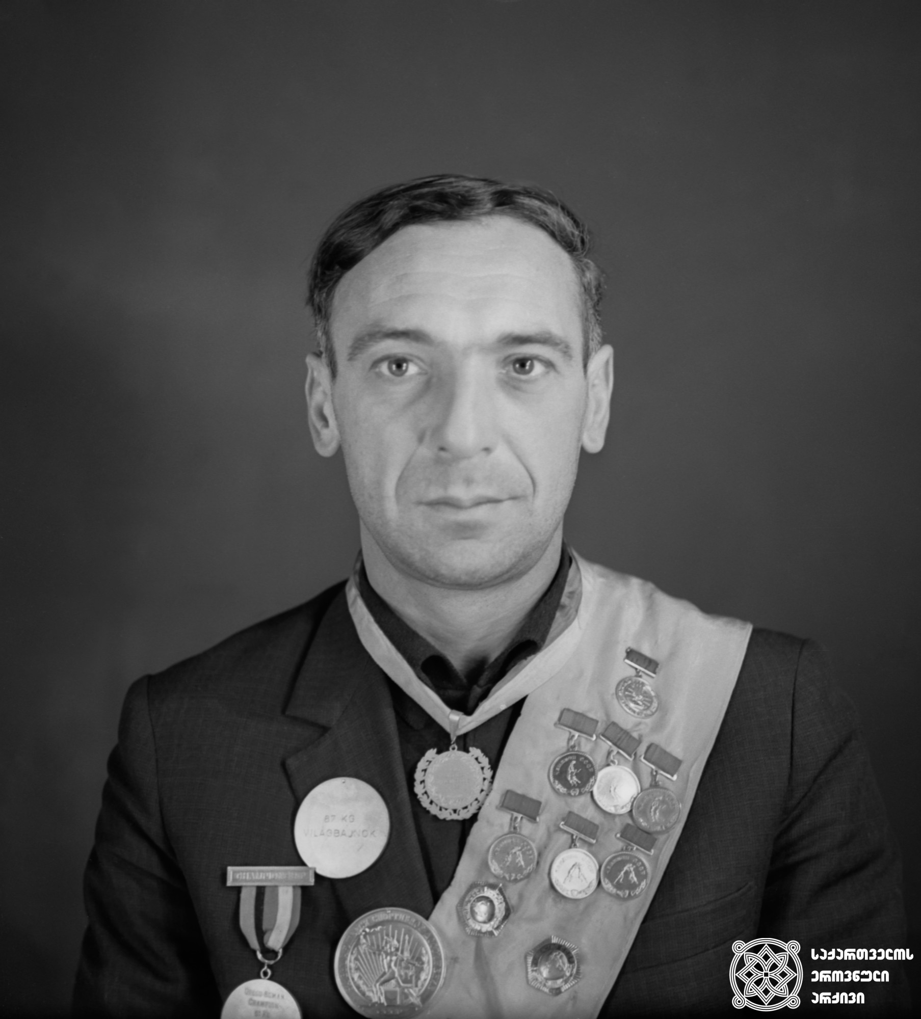 ლევან სანაძე. <br>
XV ოლიმპიური თამაშების მეორე პრიზიორი მძლეოსნობაში (1952 წელი, ჰელსინკი). <br>
Levan Sanadze. <br>
Second-prize winner of the XV Olympic Games in Triathlon (1952, Helsinki).