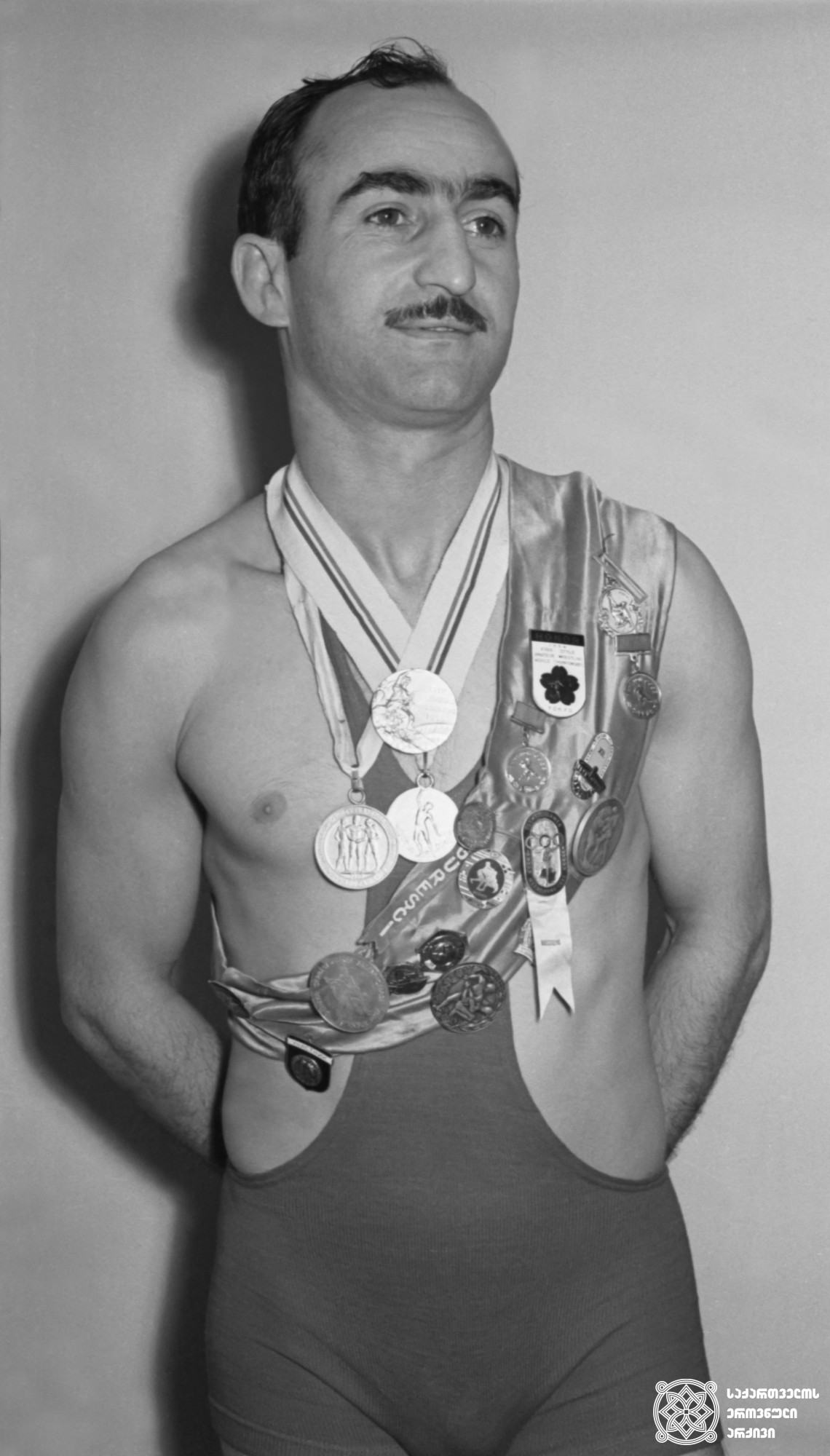 მირიან ცალქალამანიძე. <br>
1959 წელი. <br>
XVI ოლიმპიური თამაშების ჩემპიონი თავისუფალ ჭიდაობაში (1956 წელი, მელბურნი). <br>
Mirian Tsalkalamanidze. <br>
1959. <br>
Champion of the XVI Olympic Games in Wrestling Freestyle (1956, Melbourne).