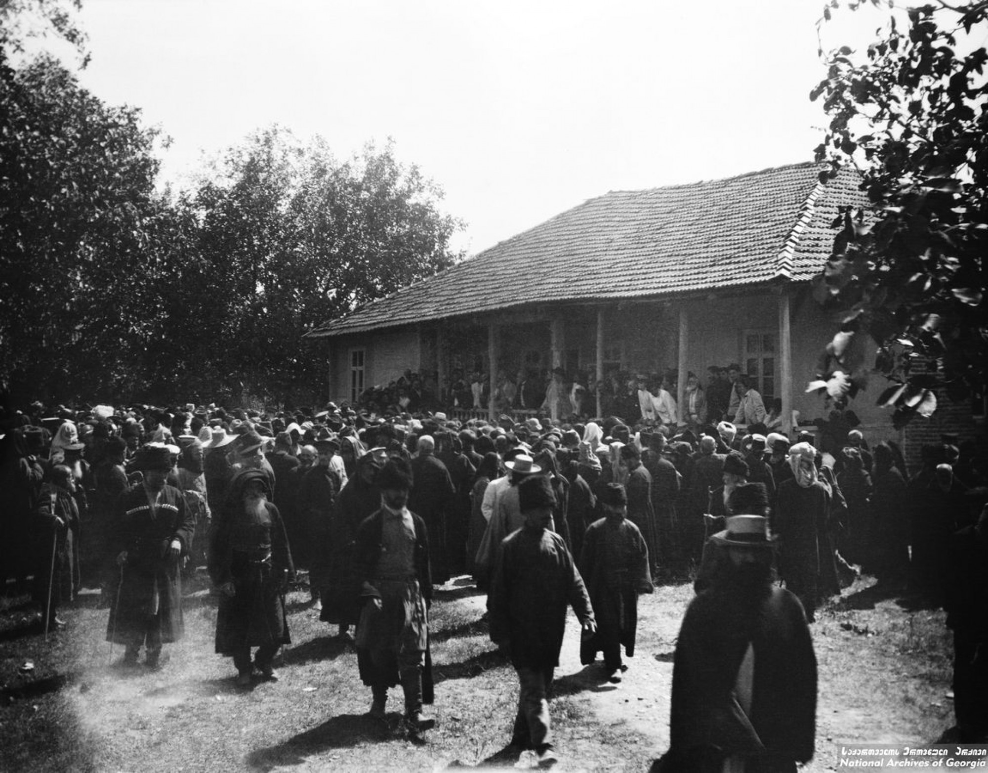 ყრილობა ივანე შარაშიძის სახლის წინ წყლის თაობაზე. <br>
ხონი. <br>
1909. <br>
Meeting held at Ivane Sharashidze’s on water issues. <br>
Khoni, Georgia. 

გვალვა აზარალებდა სოფელ დიდი-ჯიხაიშის მოსახლეობას. ამიტომ საჭირო გახდა სარწყავი არხების გაყვანა. ნიკო ნიკოლაძემ გადაწყვიტა სარწყავი არხის გამოყვანა მდინარე ცხენისწყლიდან, რომლის სათავეც იქნებოდა სოფელი მათხოჯი. არხი გაივლიდა ხონს და სოფლებს: ივანდიდს, გუბს, გოჩა-ჯიხაიშს, იანეთს და შეუერთდებოდა მდინარე გუბისწყალს. ამ საკითხზე მუშაობას ნიკოლაძე 1890-იანი წლების დასაწყისიდან შეუდგა. მან გამონახა ამ საქმით დაინტერესებული პირები, რომლებიც გვერდში ამოუდგნენ და დიდი დახმარება გაუწიეს. ასეთები იყვნენ: ხონში - ცნობილი მოღვაწე ივანე შარაშიძე, კუხში და გუბში - ნესტორ წერეთელი, სოფელ მათხოჯში კი - მელაძეები.