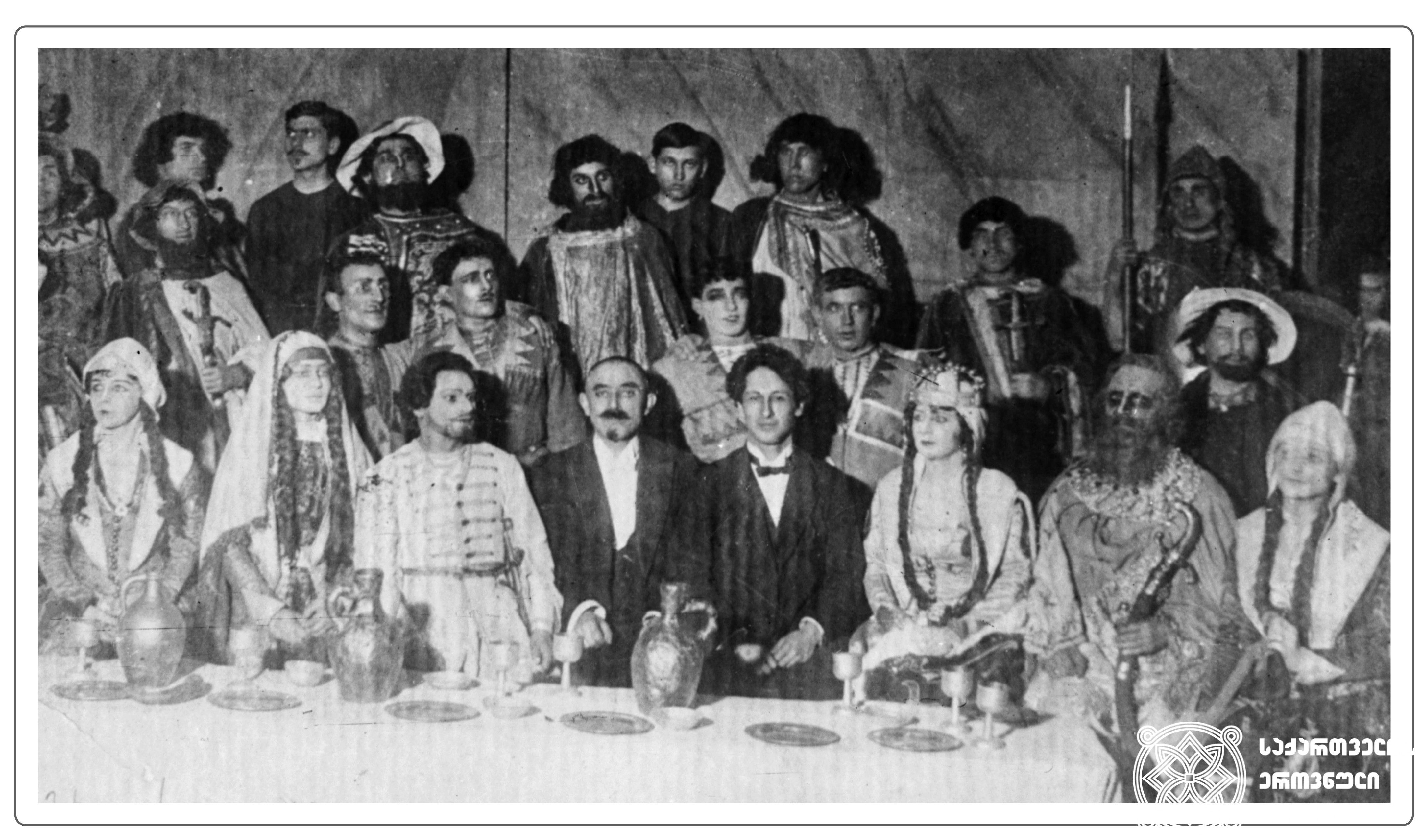 ზაქარია ფალიაშვილის ოპერა „აბესალომ და ეთერის“ პრემიერის შემდეგ გადაღებული ჯგუფური სურათი. <br>
ცენტრში, ოპერის მსახიობთა შორის, სხედან: ზაქარია ფალიაშვილი და ალექსანდრე წუწუნავა. <br>
1919 წელი, 21 თებერვალი. <br>

Group photo taken after the premiere of the opera “Abesalom and Eteri” by Zakaria Phaliashvili. <br>
Zakaria Phaliashvili and Alexandre Tsutsunava are sitting (in the center) among the opera artists. <br>
1919.